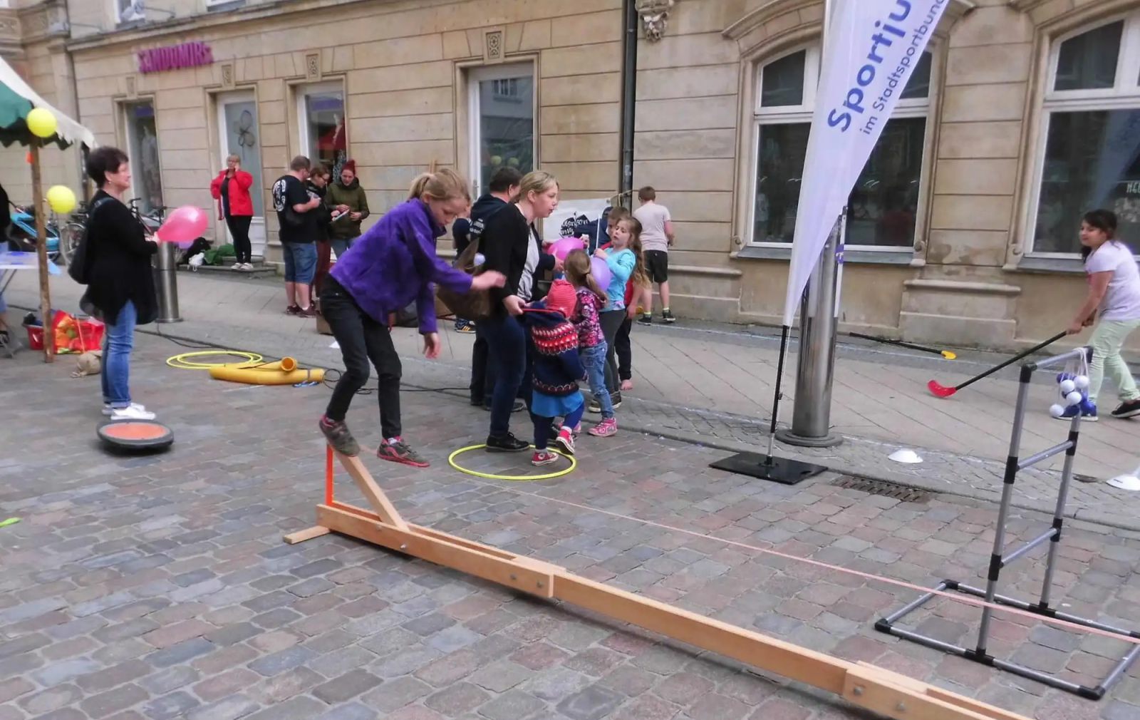 Mädchen versucht auf einer Slackline zu balancieren