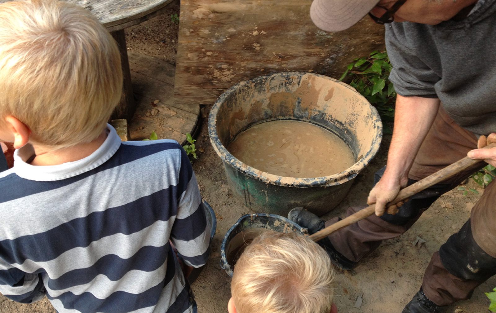 Kinder und Anleiter beim gemeinsamen Matschen