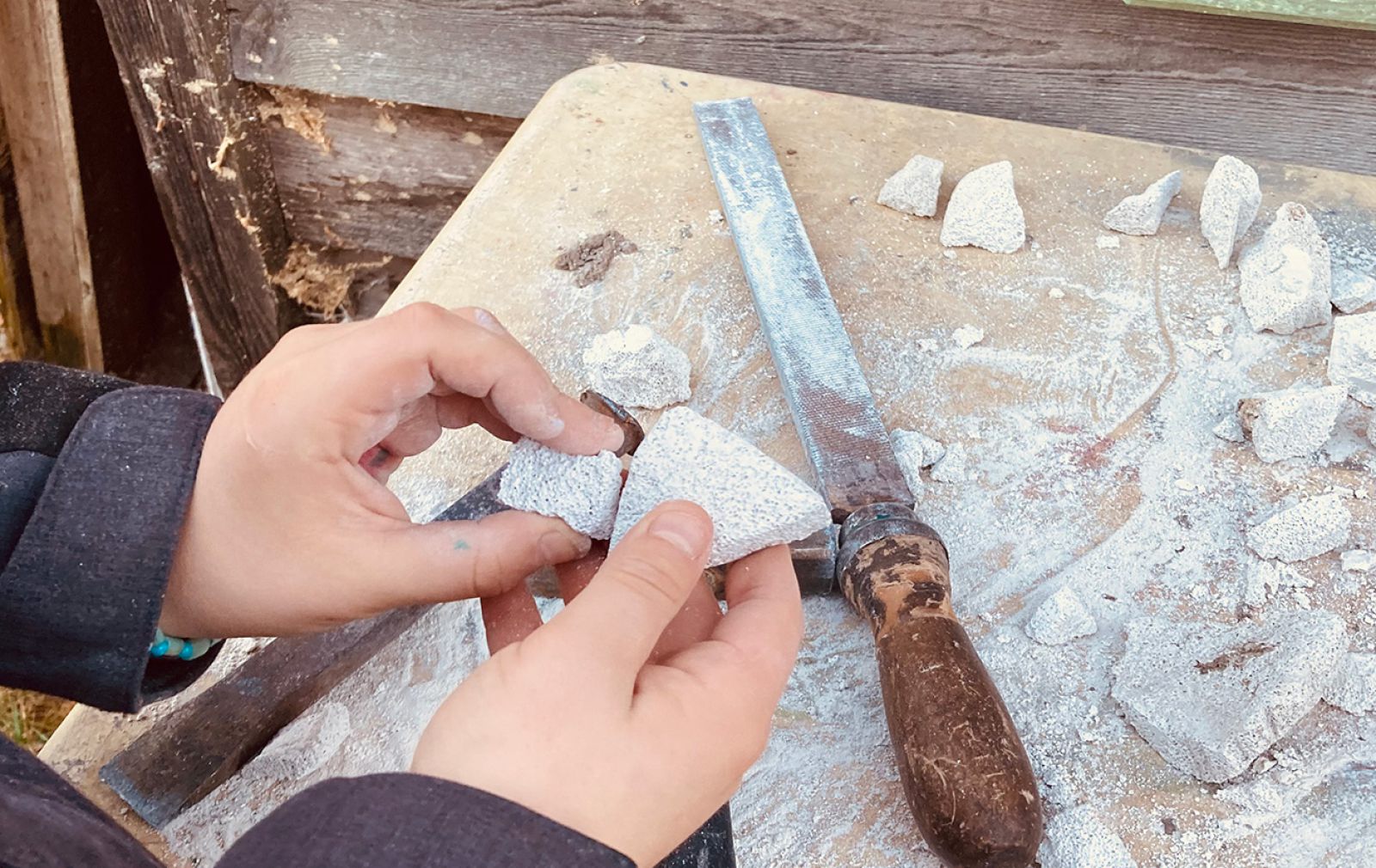 Kinderhände, die Speckstein bearbeiten